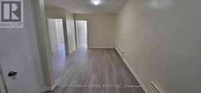 Toronto (Bedford Park-Nortown) apartment for rent - A brokerage sign is on the door of a room with wood flooring and white walls.