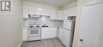 Toronto (Bedford Park-Nortown) apartment for rent - A white kitchen with a stove top oven and a refrigerator.