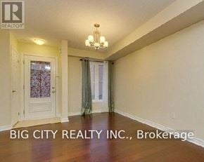 Toronto (Clairlea-Birchmount) townhouse for rent - A room with a chandelier and a door with a window.