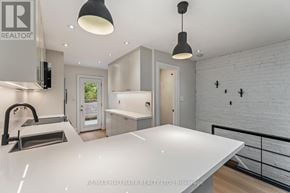 Toronto (The Beaches) duplex for rent - A white kitchen with a countertop and cabinets.