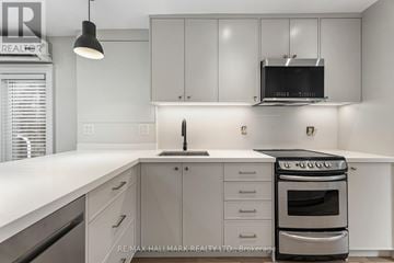 Toronto (The Beaches) duplex for rent - A modern kitchen with white cabinets and a stainless steel oven.