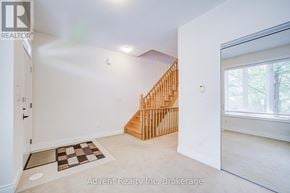Markham (Commerce Valley) townhouse for rent - A room with a wooden staircase and a checkered rug.