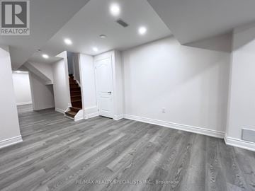 Milton (Be Beaty) apartment for rent - A spacious room with a staircase and a door.