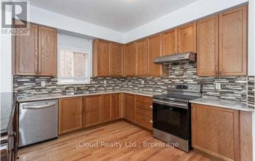 Brampton (Credit Valley) apartment for rent - A kitchen with wooden cabinets and a stone backsplash.