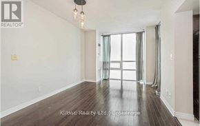 Mississauga (City Centre) condo for rent - A room with a wooden floor and a large window with curtains.