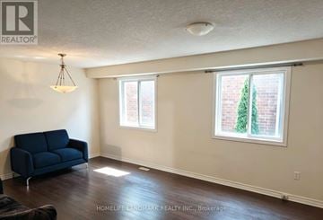 London North (North M) apartment for rent - A living room with a blue couch and a window with a tree outside.
