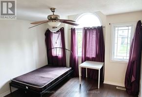 London North (North M) apartment for rent - A bedroom with a bed, a small table, and a window with purple curtains.