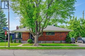 Ottawa apartment for rent - A house with a red brick exterior is shown with a tree in front of it.