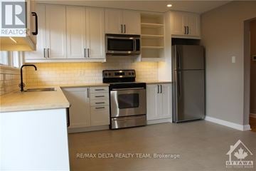 Ottawa apartment for rent - A modern kitchen with white cabinets and stainless steel appliances.