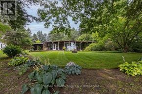 St. Catharines (Martindale Pond) apartment for rent - A lush green garden with a house in the background.