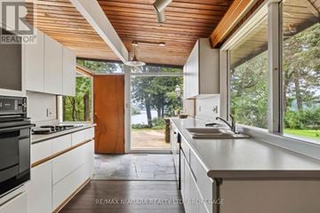 St. Catharines (Martindale Pond) apartment for rent - A modern kitchen with white cabinets and a wooden ceiling.