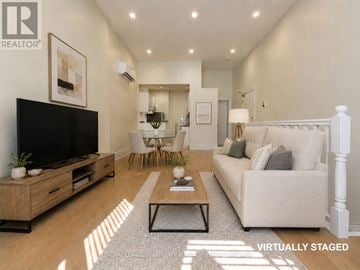 Toronto (Little Portugal) multi-family for rent - A living room with a white couch and a wooden coffee table.
