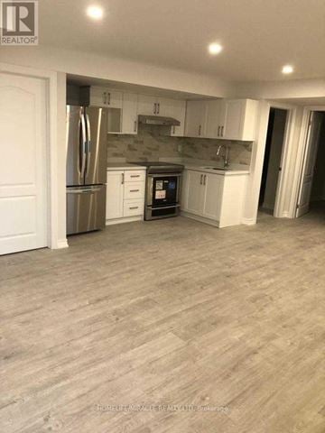 East Gwillimbury (Sharon) apartment for rent - A kitchen with white cabinets and a wooden floor.