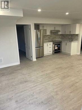 East Gwillimbury (Sharon) apartment for rent - A kitchen with a refrigerator, oven, and microwave.