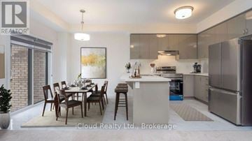 Brantford townhouse for rent - A modern kitchen with a dining table set for six.