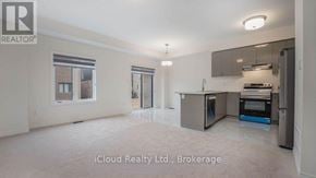 Brantford townhouse for rent - A spacious kitchen with stainless steel appliances and a dining area with a table and chairs.