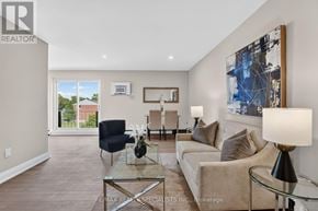 St. Catharines (Secord Woods) multi-family for rent - A well-lit living room with a glass coffee table and a large painting on the wall.