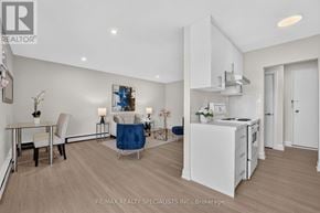 St. Catharines (Secord Woods) multi-family for rent - A modern kitchen with white appliances and a dining table set for two.