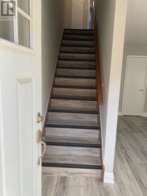 Hamilton (Hampton Heights) townhouse for rent - A staircase with wooden steps and a white door.