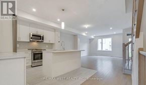 Ottawa townhouse for rent - A spacious kitchen with white cabinets and a microwave above the oven.