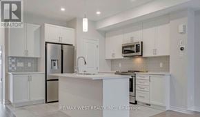 Ottawa townhouse for rent - A modern kitchen with white cabinets and appliances.