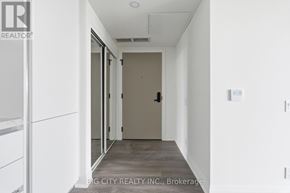 Toronto (Leaside) condo for rent - A hallway with a door and a wall-mounted light fixture.