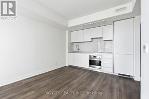 Toronto (Leaside) condo for rent - A white kitchen with wood flooring and white cabinets.