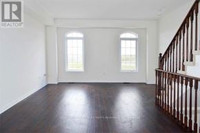 Ajax (Northeast Ajax) townhouse for rent - A spacious room with wooden floors and a staircase on the right side.