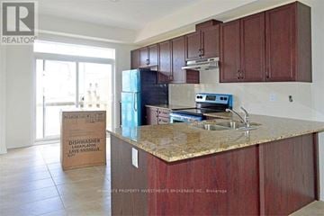 Ajax (Northeast Ajax) townhouse for rent - A kitchen with brown cabinets and a countertop is being staged for a real estate listing.