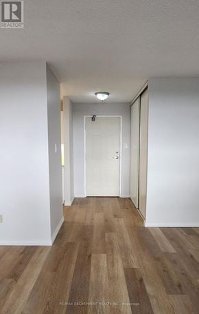 Brantford condo for rent - A hallway with wood flooring and white walls.