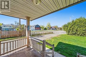 Ottawa apartment for rent - A wooden deck with a railing and a view of a street with houses.