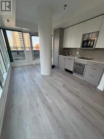 Toronto (Church-Yonge Corridor) condo for rent - A spacious kitchen with white cabinets and a grey floor.