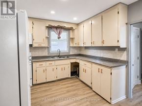 Oshawa (Lakeview) apartment for rent - A kitchen with wooden cabinets and a refrigerator.