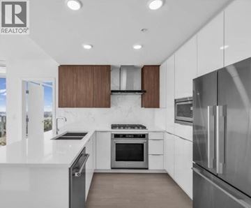 Burnaby apartment for rent - A modern kitchen with stainless steel appliances and wooden cabinets.