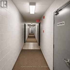 St. Catharines (Oakdale) condo for rent - A long hallway with a sign that says "Electrical" on the door.