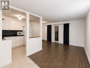 St. Catharines (Oakdale) condo for rent - A spacious room with a kitchen area and a dining table.