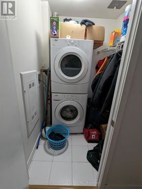 Toronto (Waterfront Communities) condo for rent - A small laundry room with a washer and dryer stacked on top of each other.