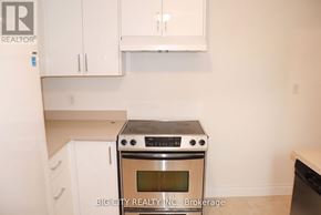 Toronto (Ionview) apartment for rent - A white oven with a stove top sits in a kitchen with white cabinets.