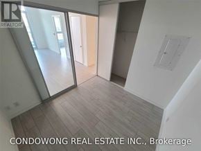 Vaughan (Vaughan Corporate Centre) condo for rent - A room with a wooden floor and white walls, with a glass door leading to another room.