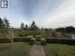 West Vancouver apartment for rent - A well-manicured garden with a pathway leading to a hedge.
