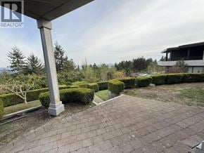 West Vancouver apartment for rent - A well-maintained outdoor patio area with a brick floor and neatly trimmed hedges.