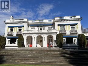 Vancouver apartment for rent - A large white building with a balcony and a blue stripe on the roof.