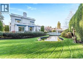 Vancouver apartment for rent - A white house with a blue roof and a pond in front of it.