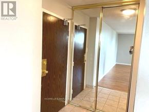 Brampton (Queen Street Corridor) condo for rent - A room with a wooden door and a mirror on the wall.