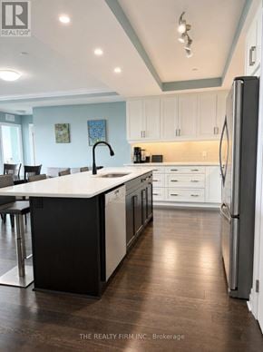 London East (East F) condo for rent - A modern kitchen with white cabinets and a black island.