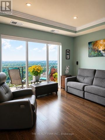 London East (East F) condo for rent - A living room with a grey couch and a wooden floor.