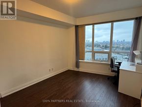 Markham (Thornhill) condo for rent - A room with a desk and a window overlooking a cityscape.