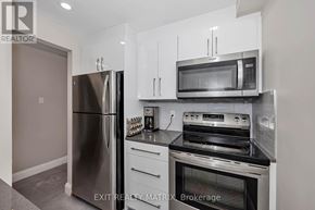 Ottawa condo for rent - A kitchen with a refrigerator, oven, and microwave.