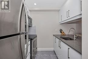 Ottawa condo for rent - A modern kitchen with stainless steel appliances and white cabinets.
