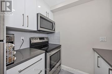 Ottawa condo for rent - A kitchen with a stove top oven and microwave.